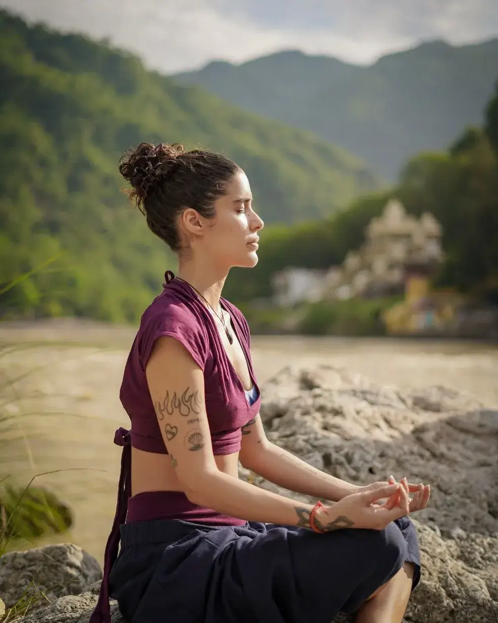 Yoga teacher training student meditating beside the Ganga in Rishikesh